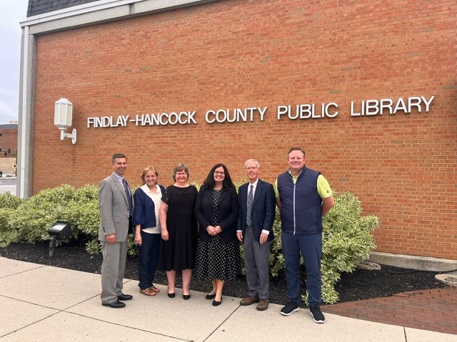 board members outside in front of library sign